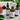 Four bottles of 'Naturally Soap' with droppers on a white surface with green leaves in the background.