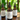 Three bottles of 'Naturally Soap' on a wooden surface with a blurred green background